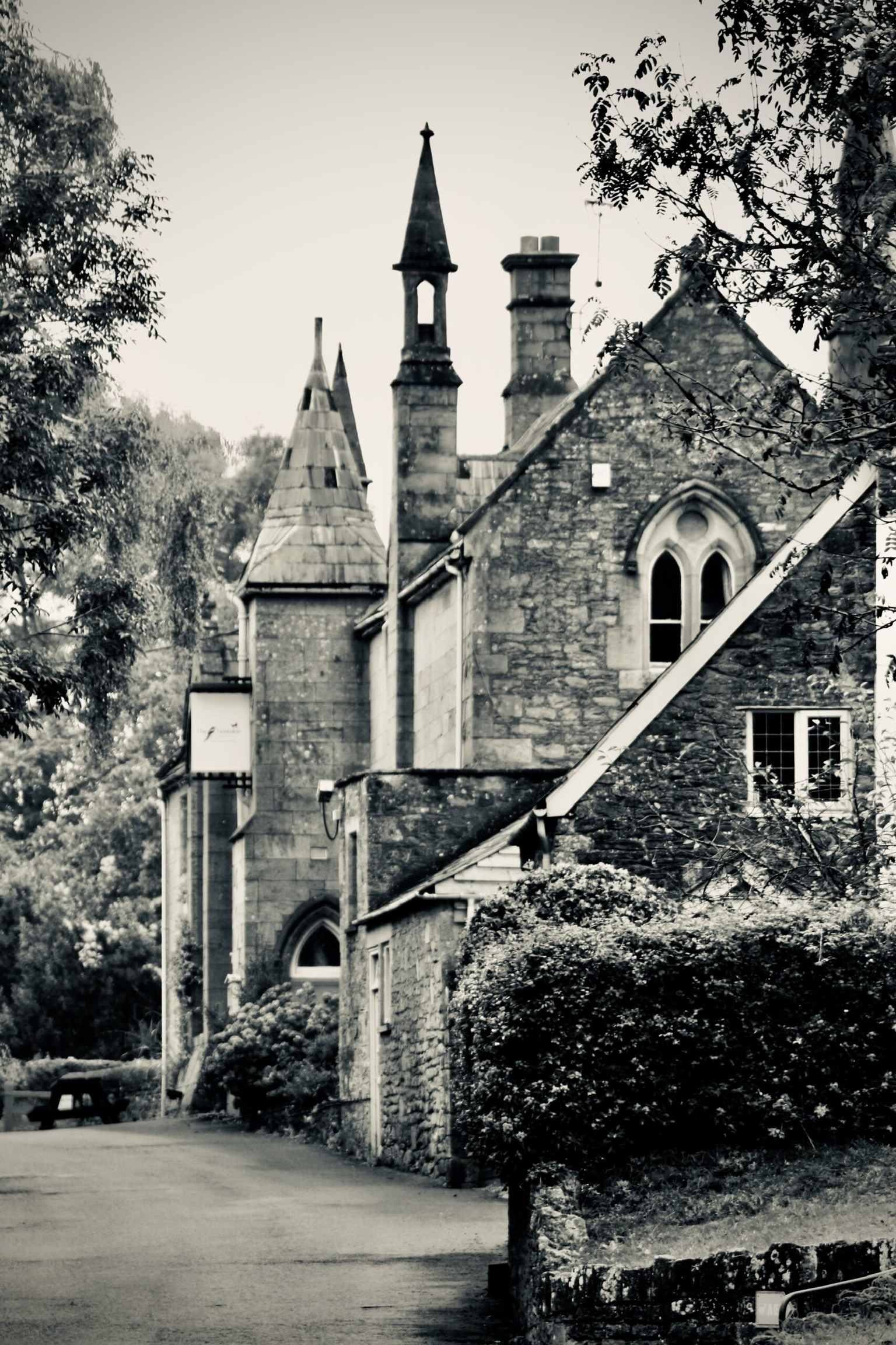 The Hostelrie at Goodrich, an 1830s stone building with a small spire, gothic-arched windows and stone tracery.